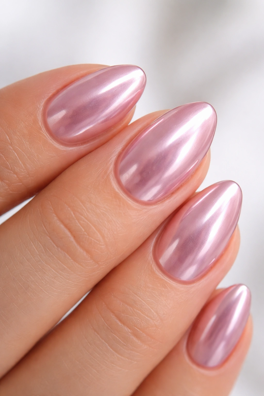 Close-up of a short almond nail with reflective chrome finish
