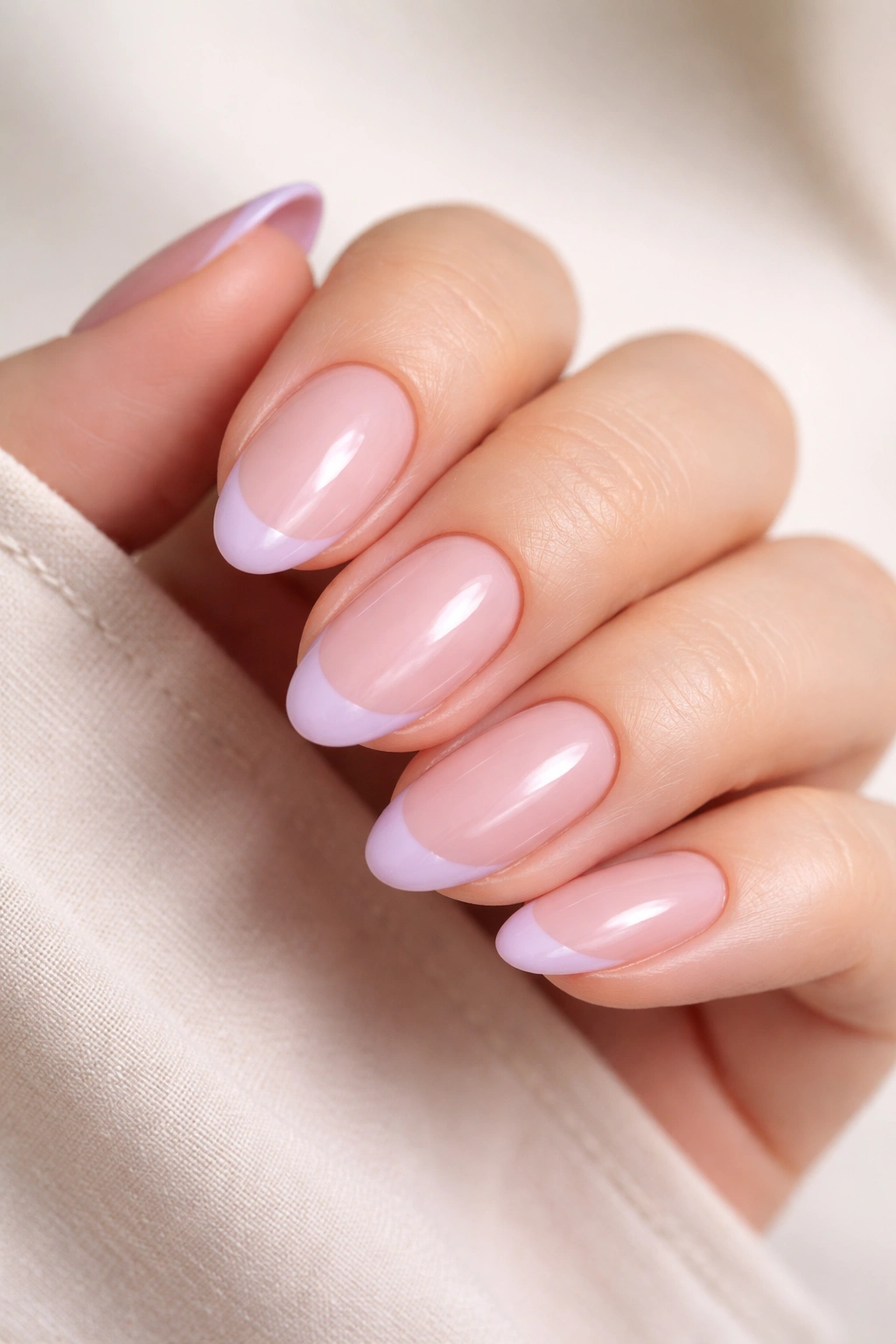 Dusty pink base with thin lilac tips on short almond nails