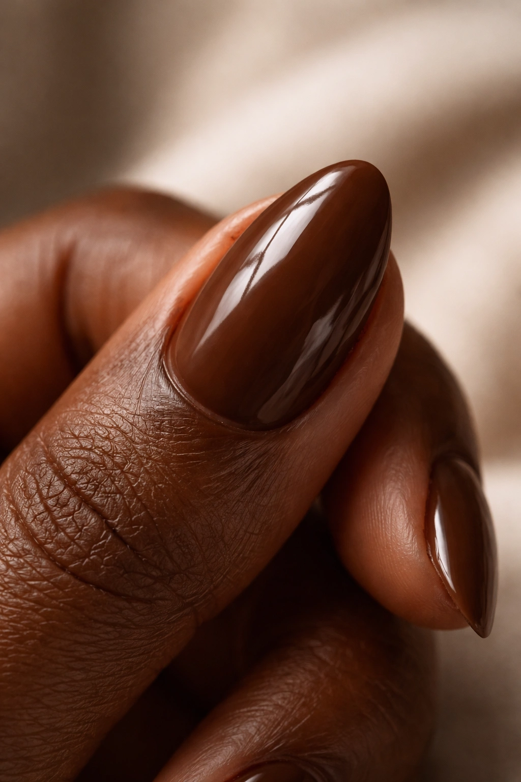 Close-up of a short almond nail with a glossy, clean look on natural skin.