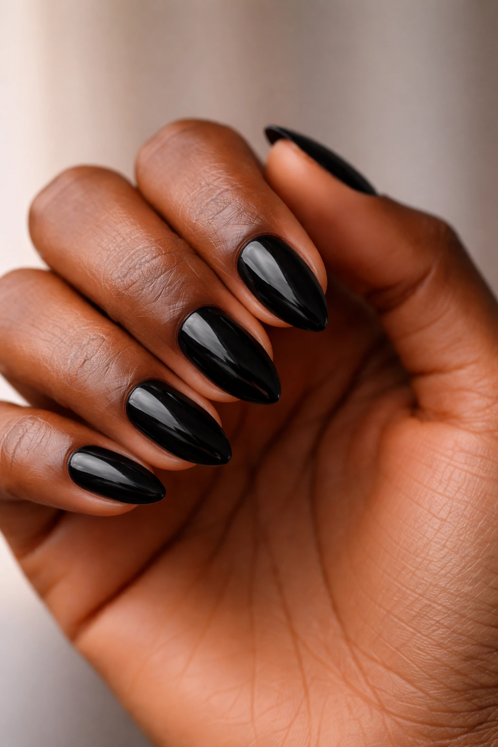 Close-up of short almond nails on hand with neat tapering