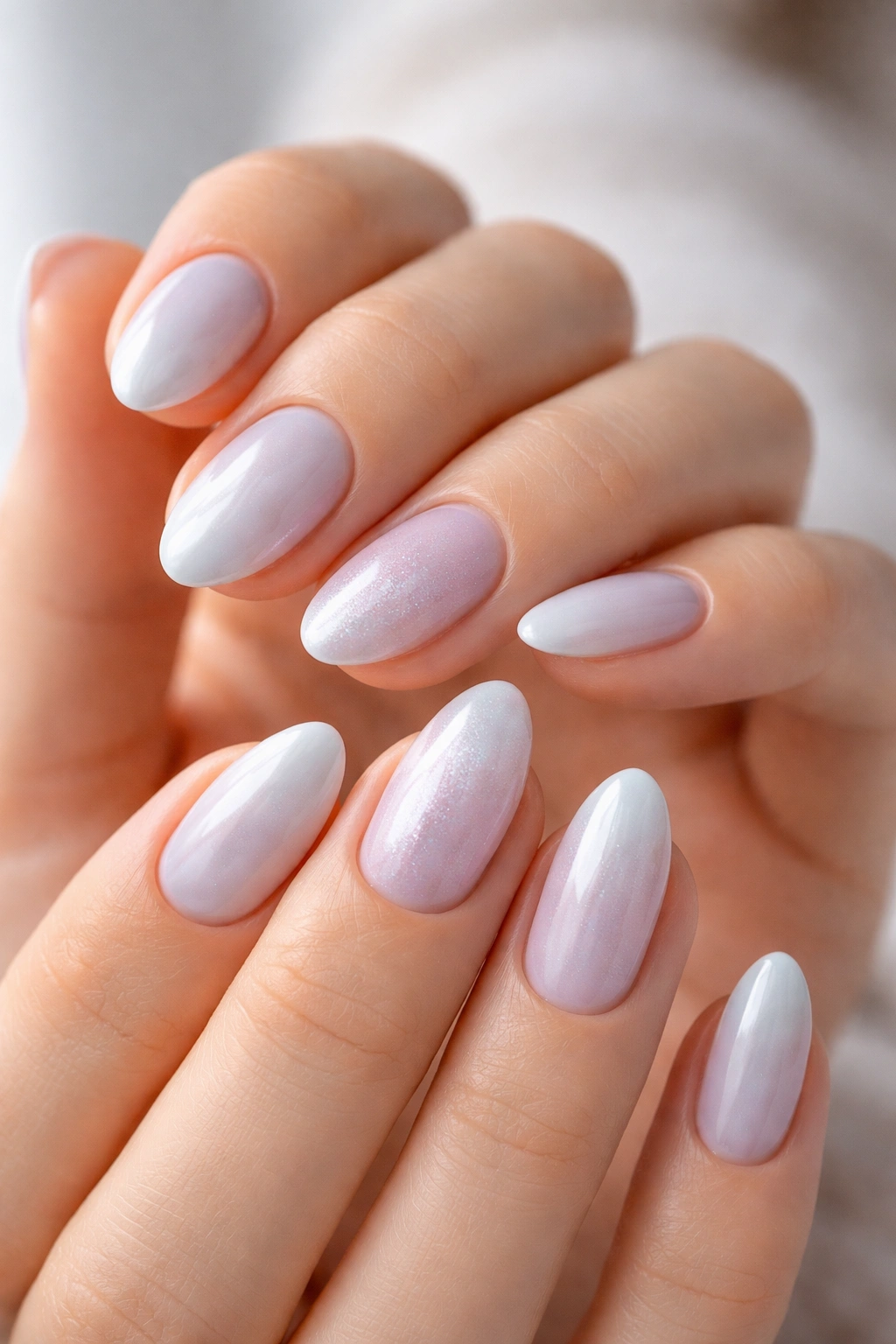 Close-up of short almond nails with cool icy tones showing balanced shape