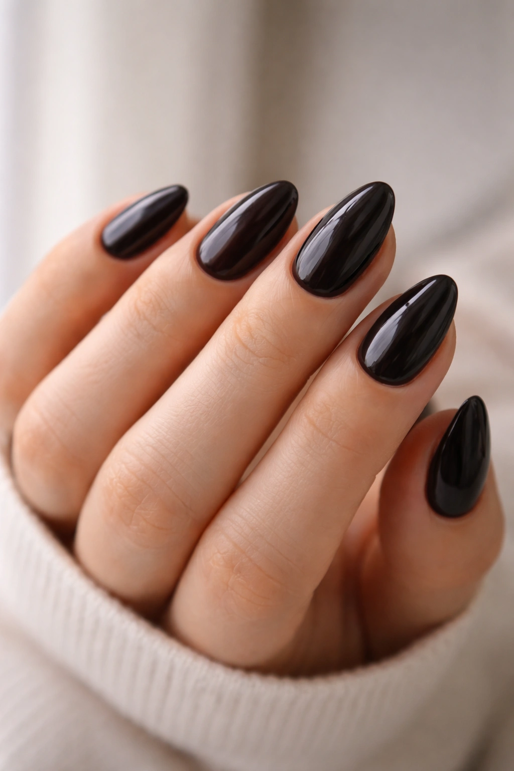 Close-up of a hand with uniform short almond nails showing consistent taper