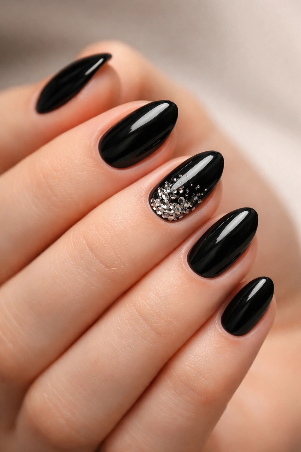 Close-up of a hand highlighting a focal glossy nail among short black almond nails