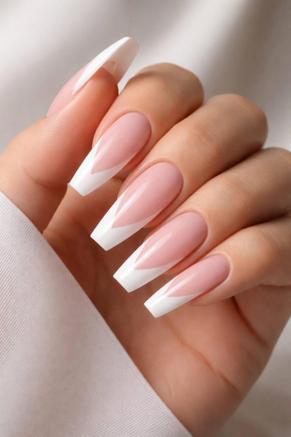 Nails with diagonal white tips on a pale pink base