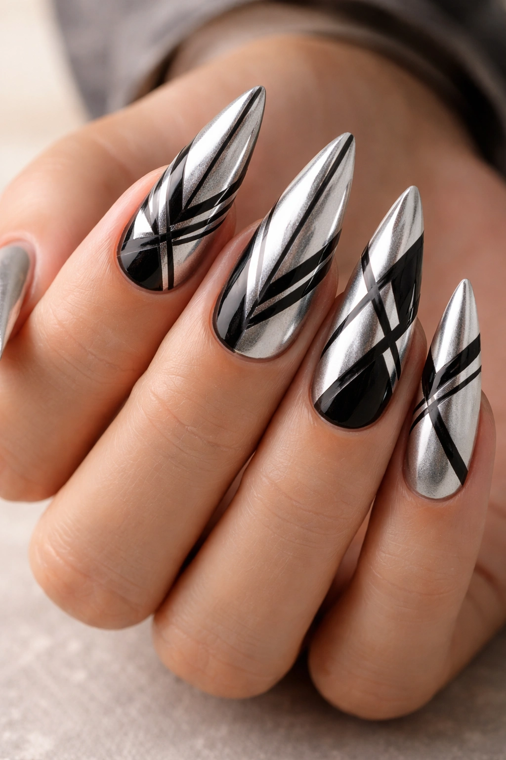 Stiletto nails with silver base and black geometric patterns