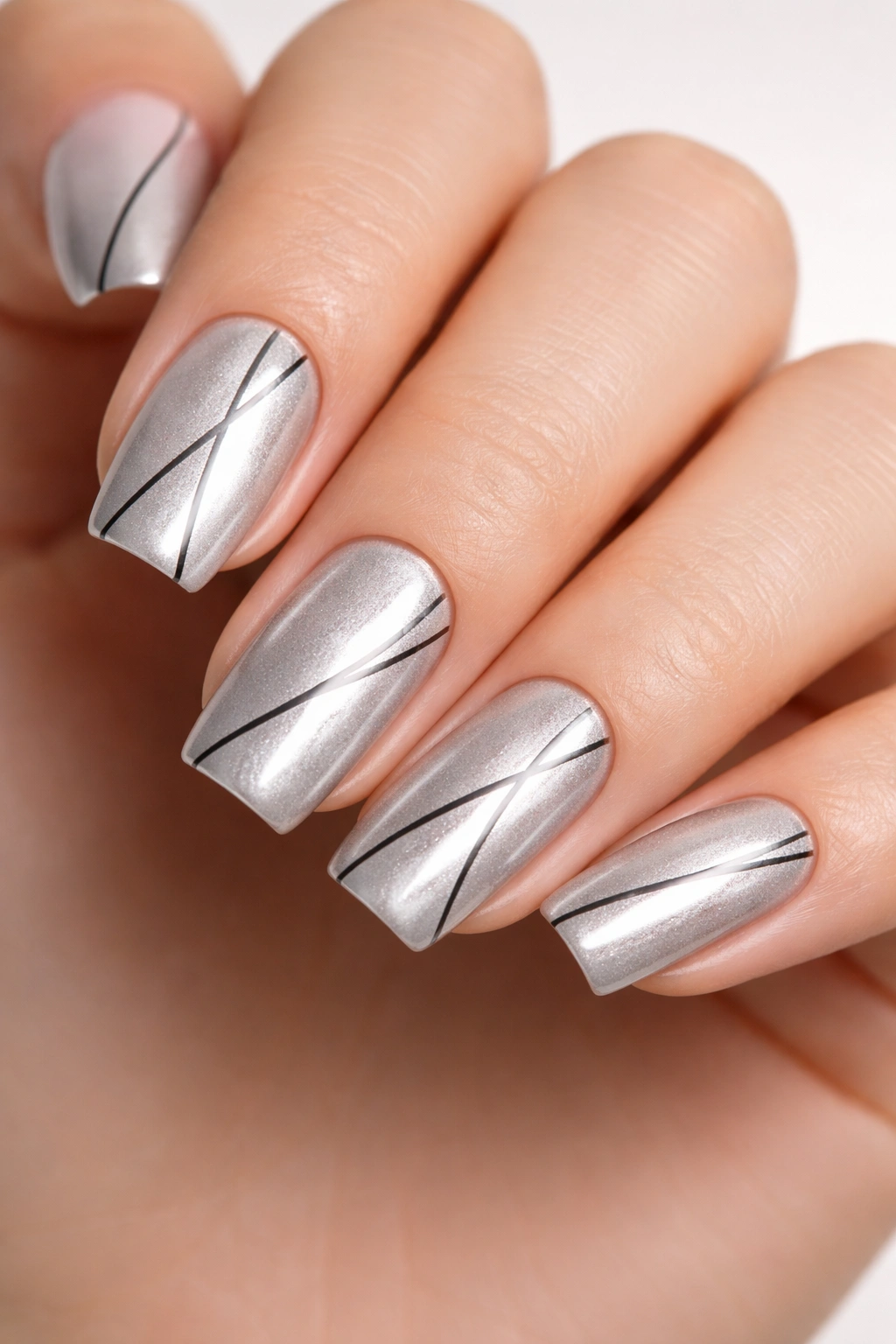 Silver cat eye nails with black linear designs on soft square nails