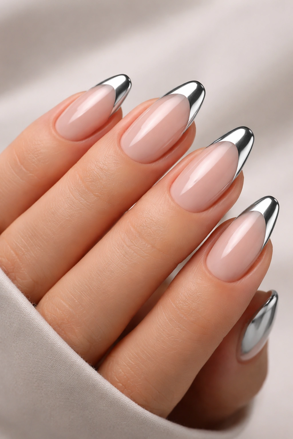 Nude base nails with silver chrome tips in a French manicure style