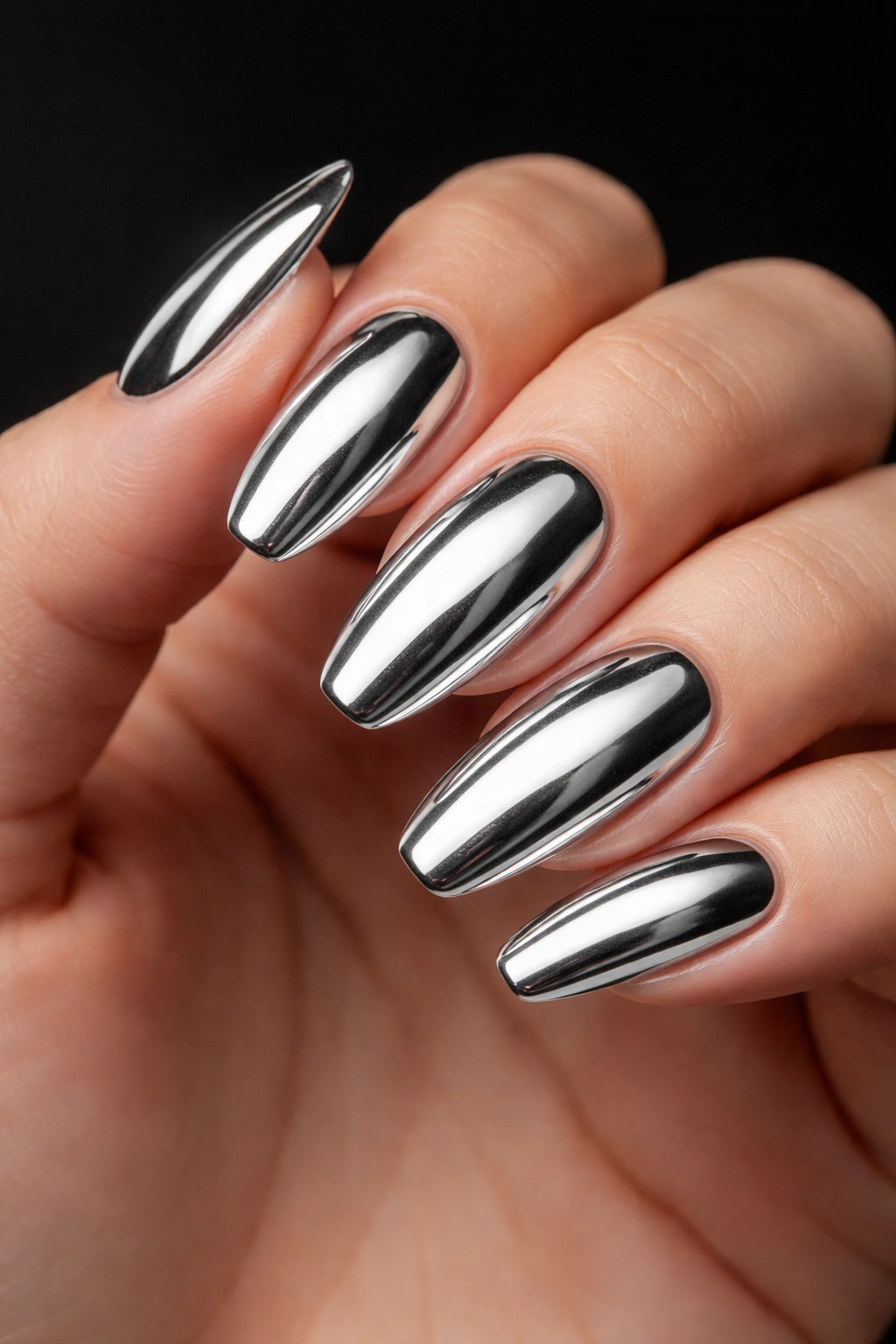 Close-up of silver chrome nails with mirror finish.