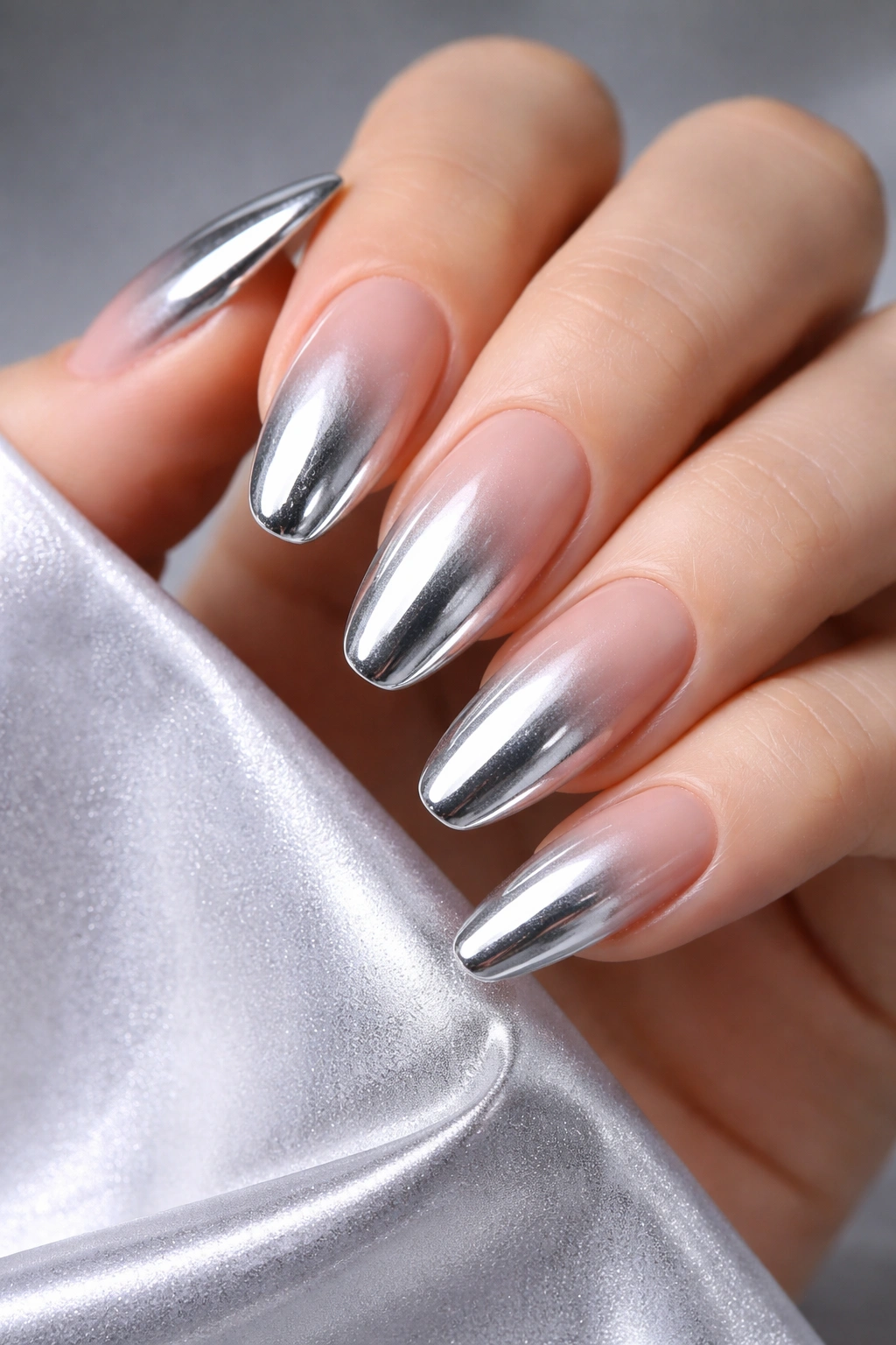 Close-up of silver chrome ombré nails with gradient