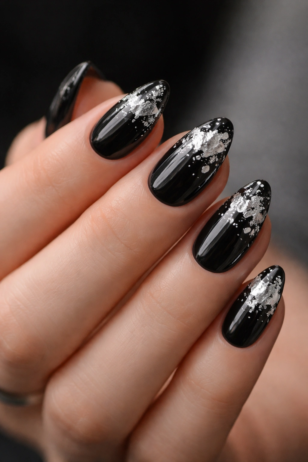 Short almond nails with black base and silver foil shards