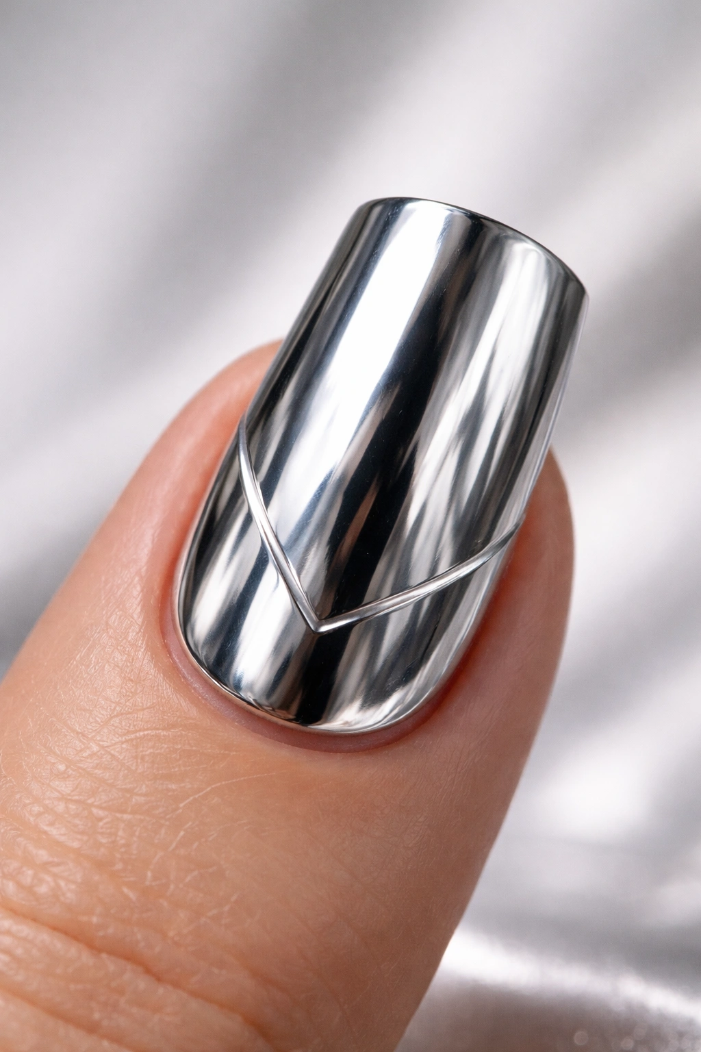 Close-up of a single duck nail with silver mirror chrome and a minimalist geometric accent line in studio lighting
