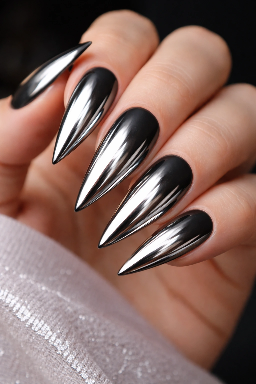 Close-up of nails with silver mirror powder over black matte base