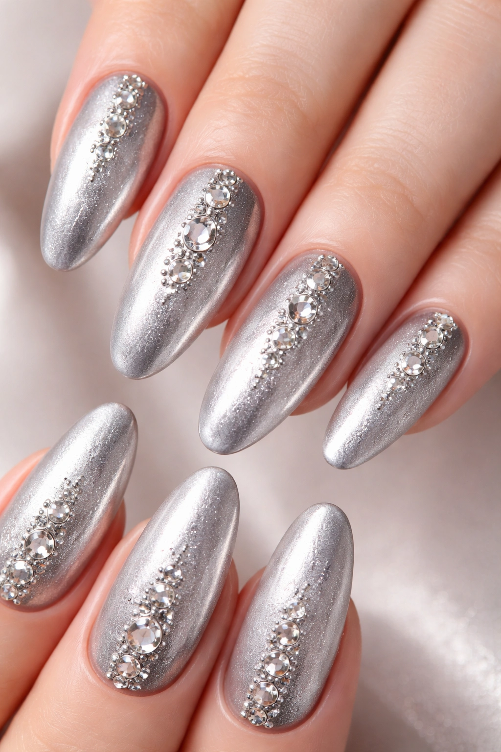 Close-up of silver-based nails with 3D studs and rhinestones