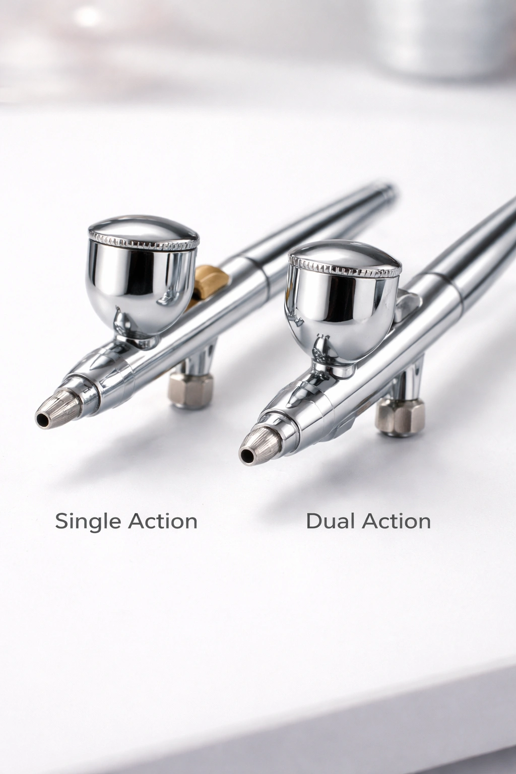 Side-by-side airbrush guns showing single action and dual action mechanisms