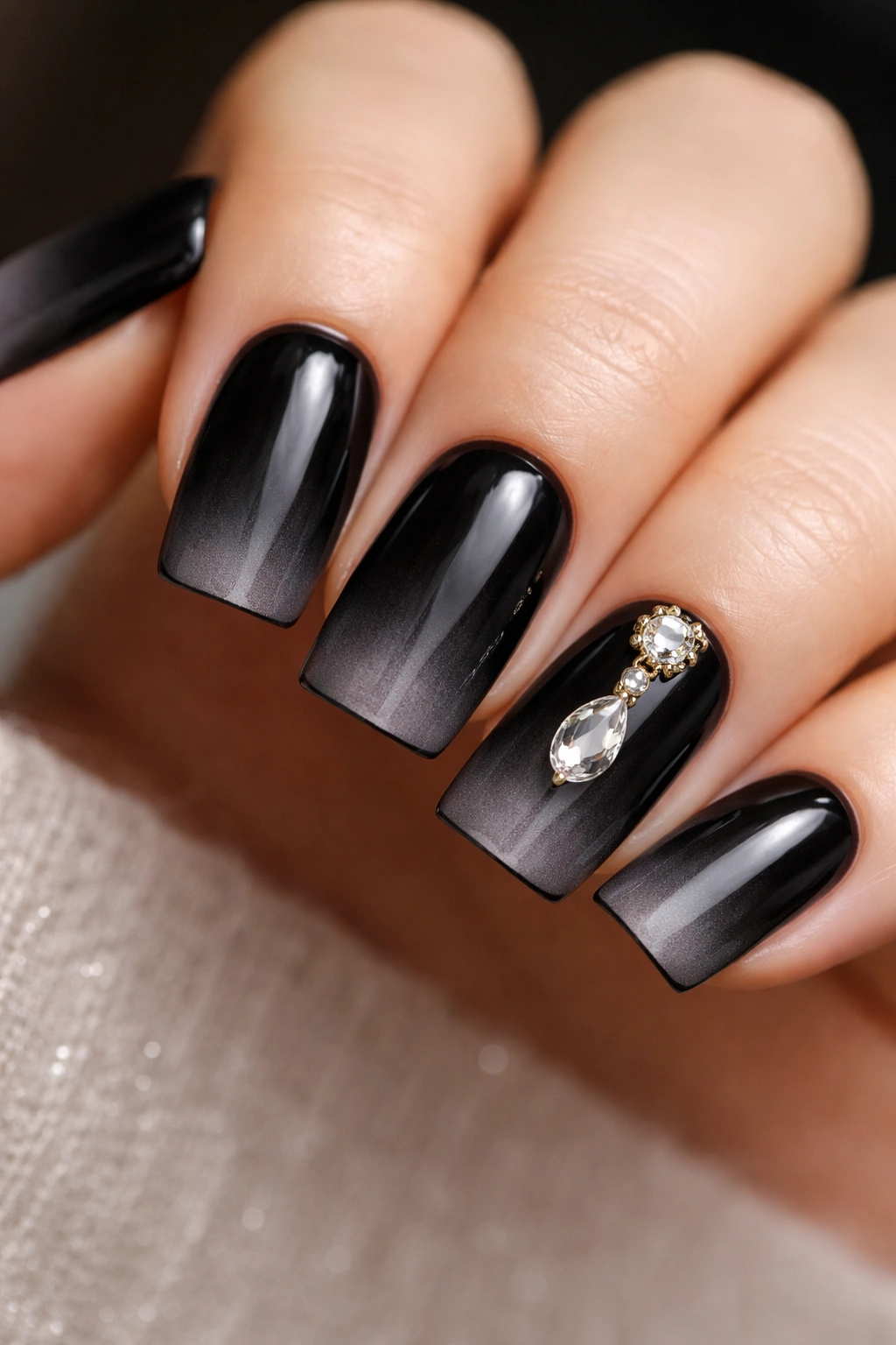 Close-up of black duck nails with a single charm on ring finger
