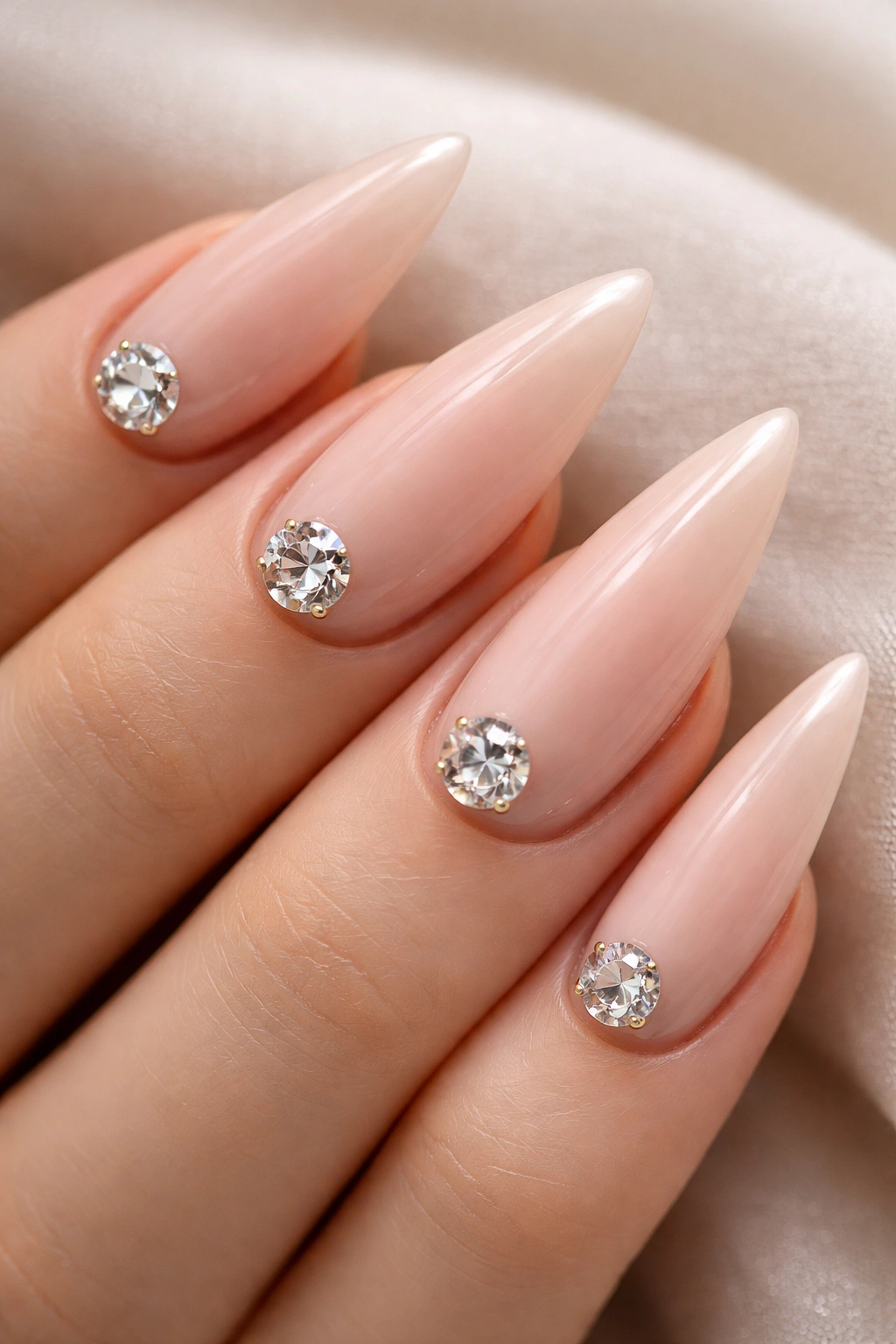 Nude-based nails with a single large rhinestone on each nail