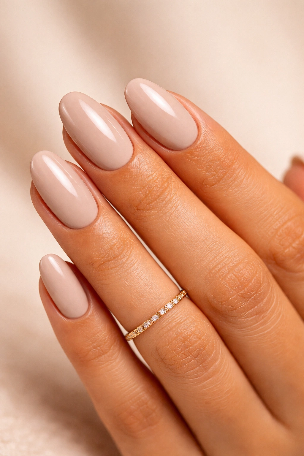 Greige nude nails on warm skin with gold ring