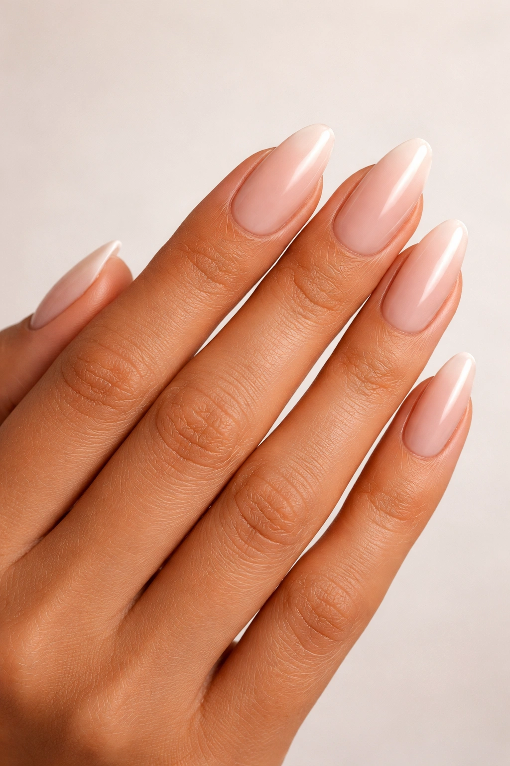Close-up of hand showing skin tone and nail bed with a structured nail shape