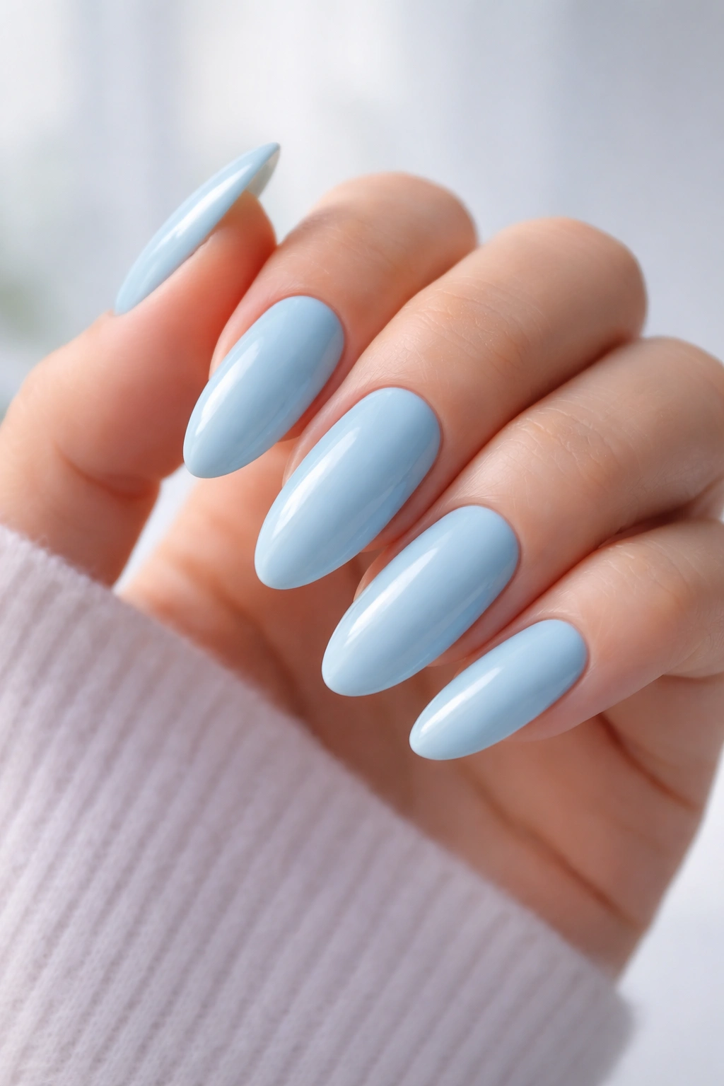 Close-up of long oval sky blue nails with a creamy, open finish
