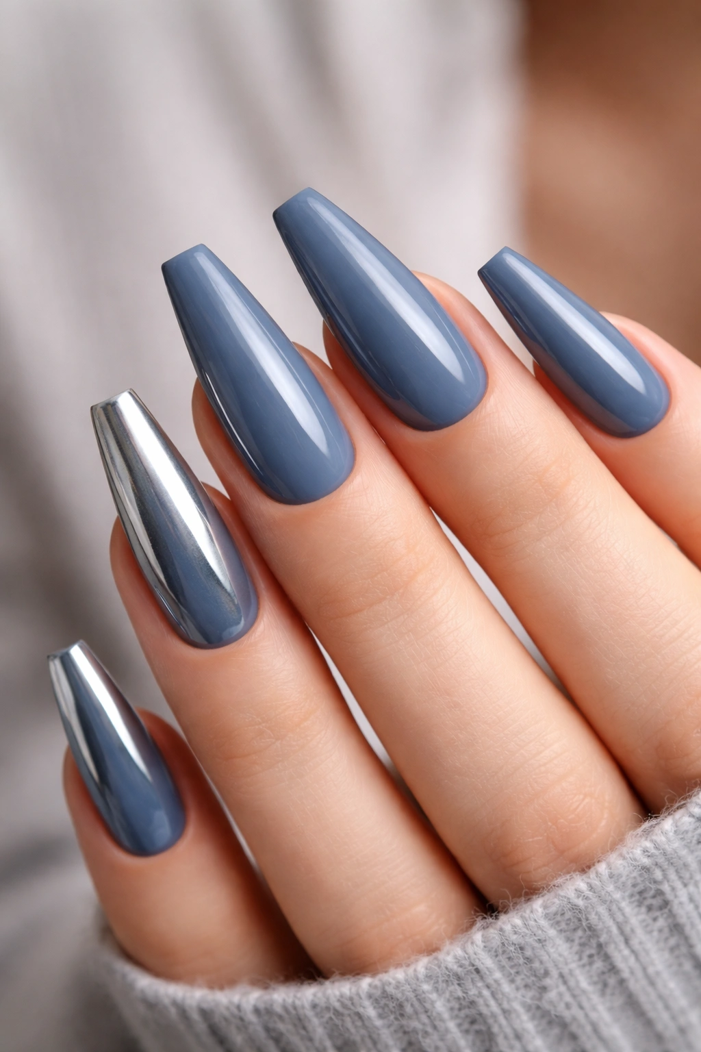 Close-up of slate blue coffin nails with metallic tip accents on selected nails