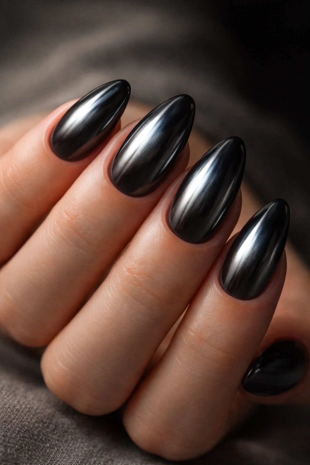 Close-up of smoked silver black chrome nails on short almond shape