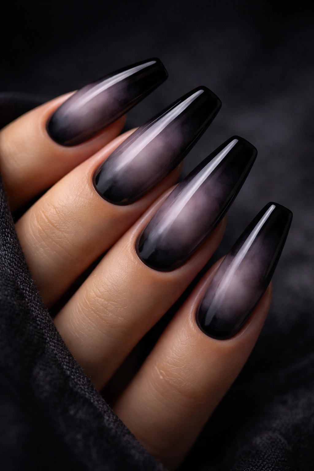 Close-up of smoky aura nails with black burnt edges on ballerina tips