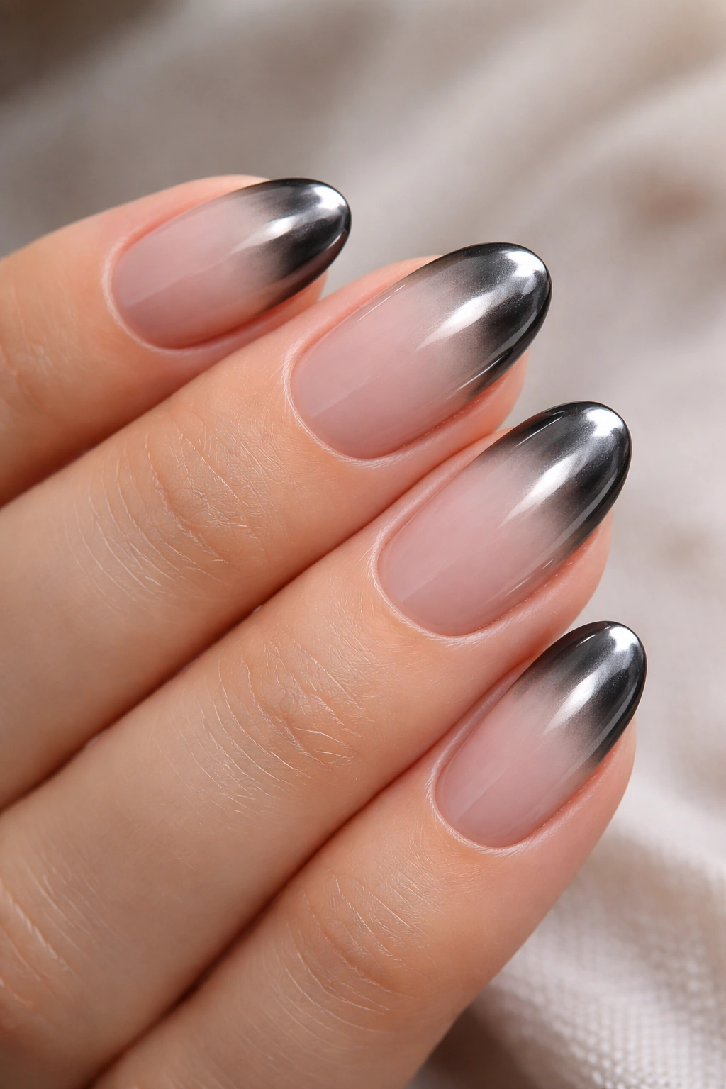 Short oval nails with smoky chrome tips on pale nude base