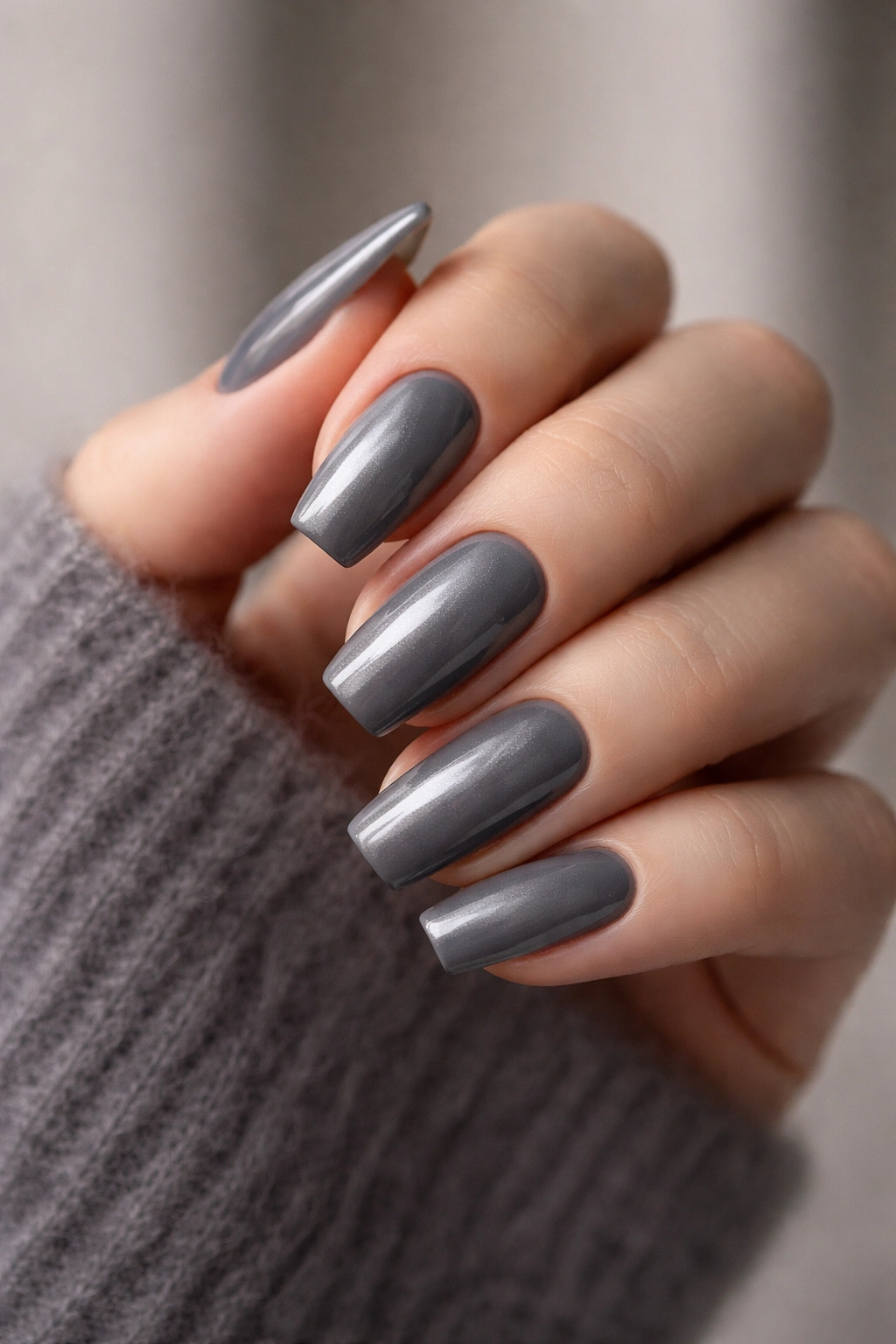 Close-up of hand with smoky gray nails pearlescent finish
