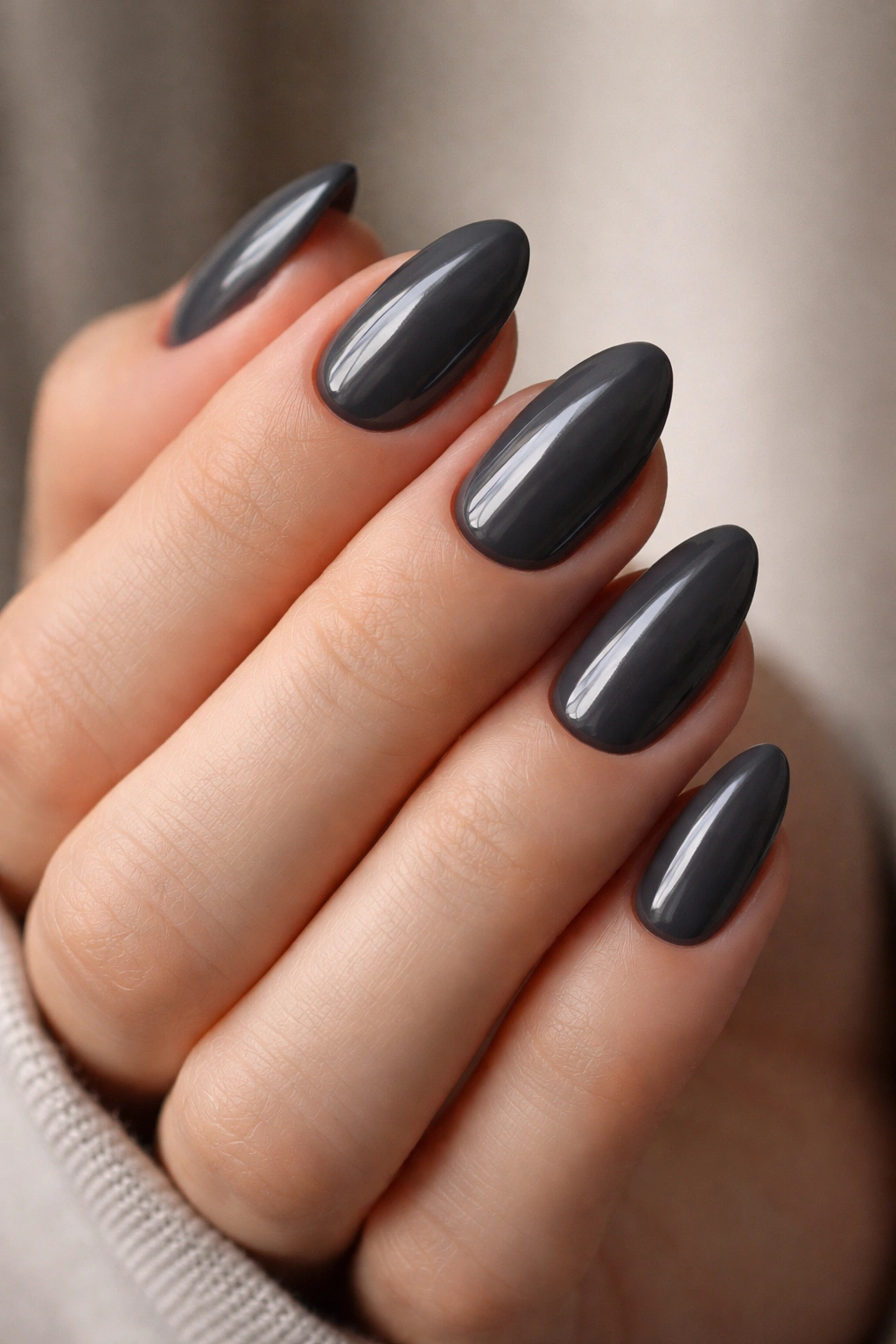 Close-up of smoky gray almond nails on a hand