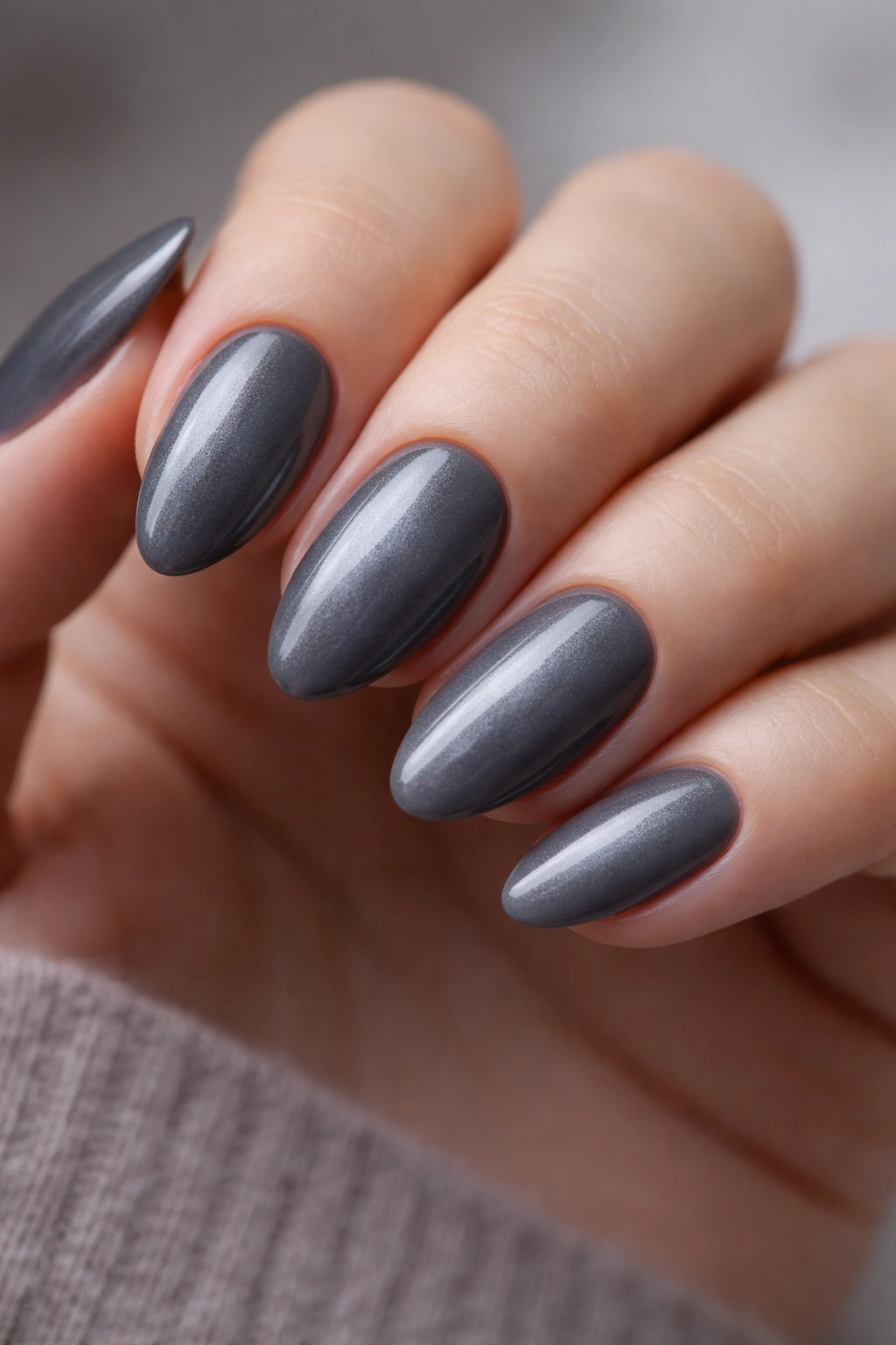 Close-up of short almond nails in smoky gray with hazy surface