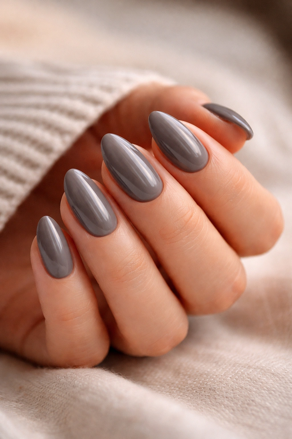 Close-up of smoky gray almond nails with warm undertones