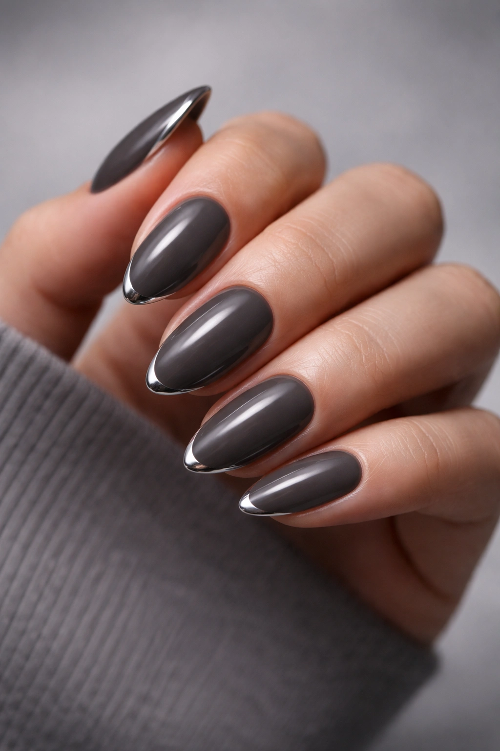 Close-up of short almond nails in smoky gray with a thin chrome edge on each tip