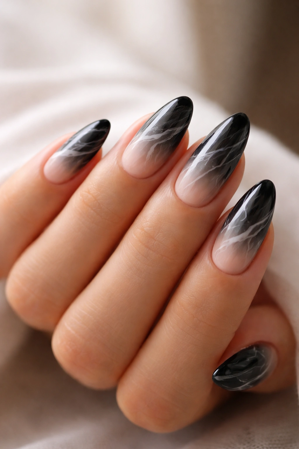 Almond nails with nude-to-black gradient and subtle marble veins