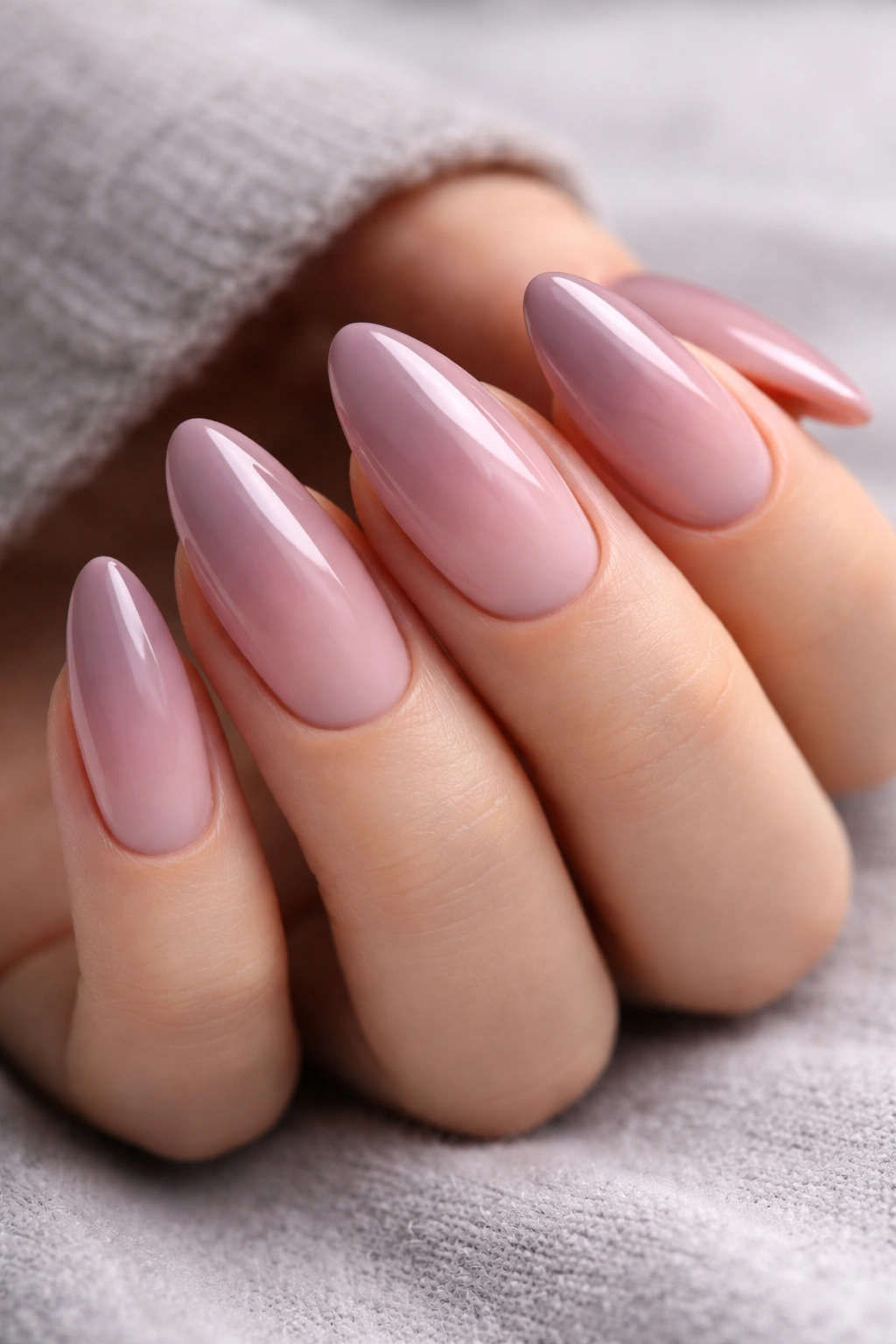 Macro close-up of almond nails gradient smoky mauve to dusty pink on a gray background