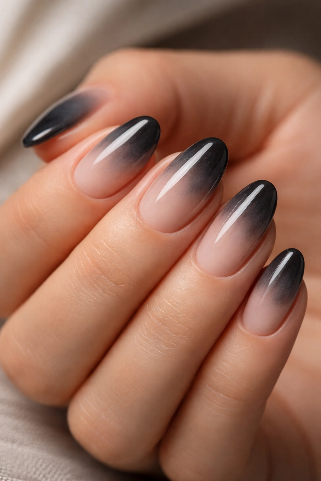 Close-up of short almond nails with smoky ombre gradient
