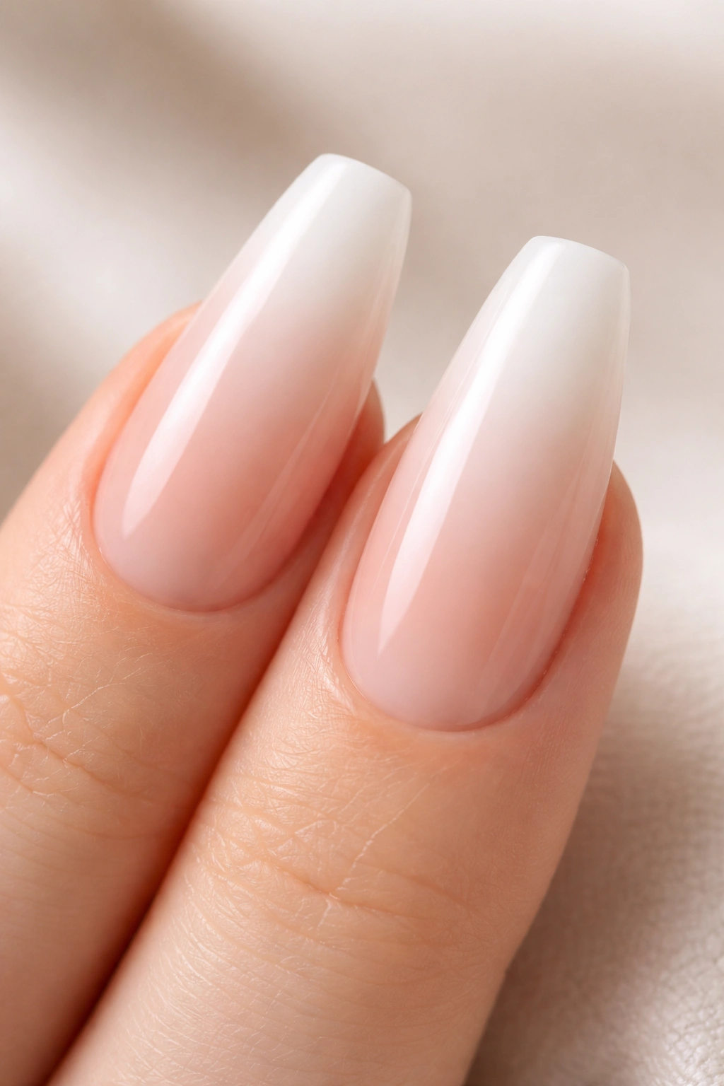 Two nails with a seamless nude-to-milky white ombre starting near the last third