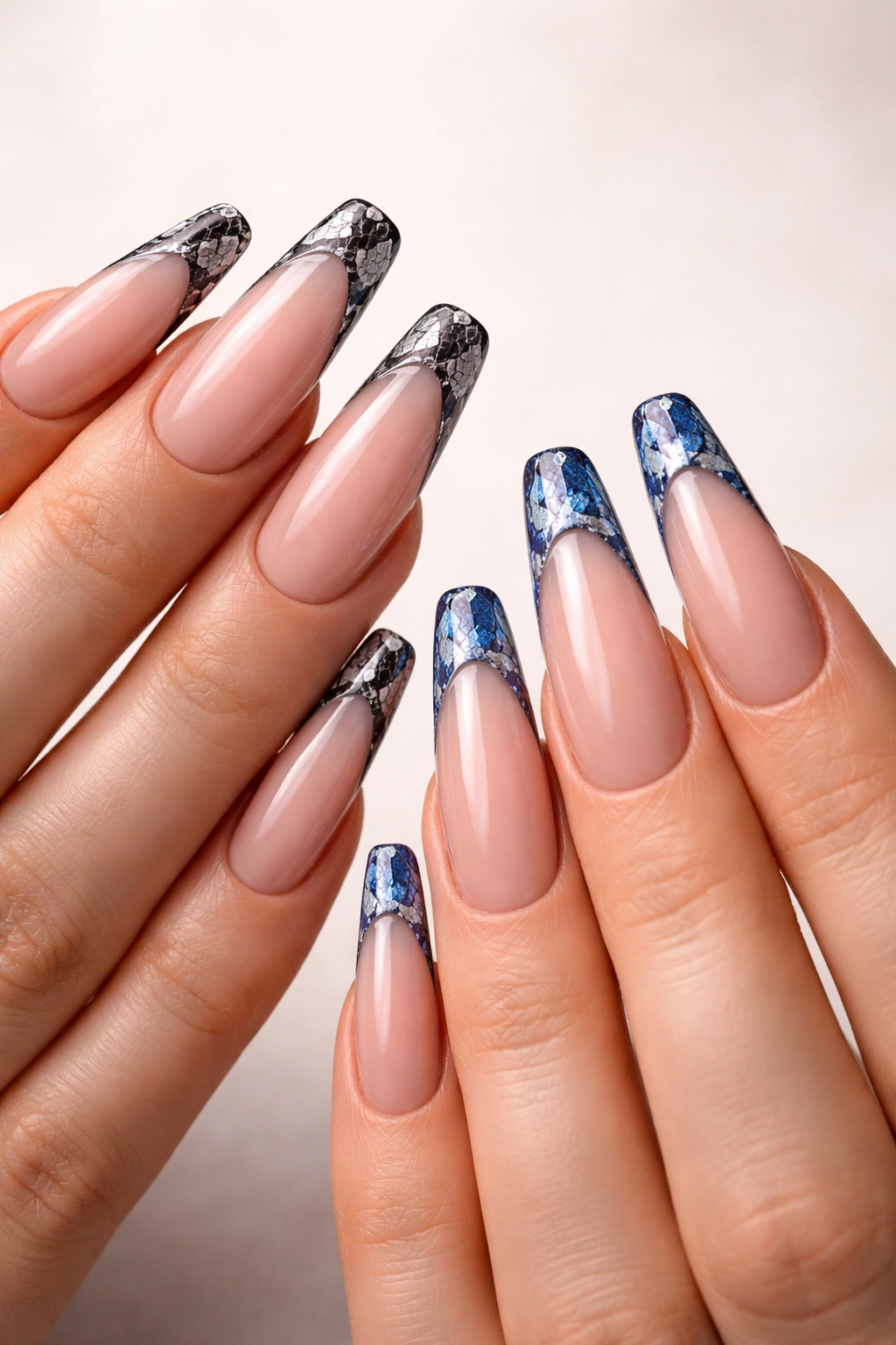 Close-up of long snake print edge nails on two hands with black-white and blue-silver colorways