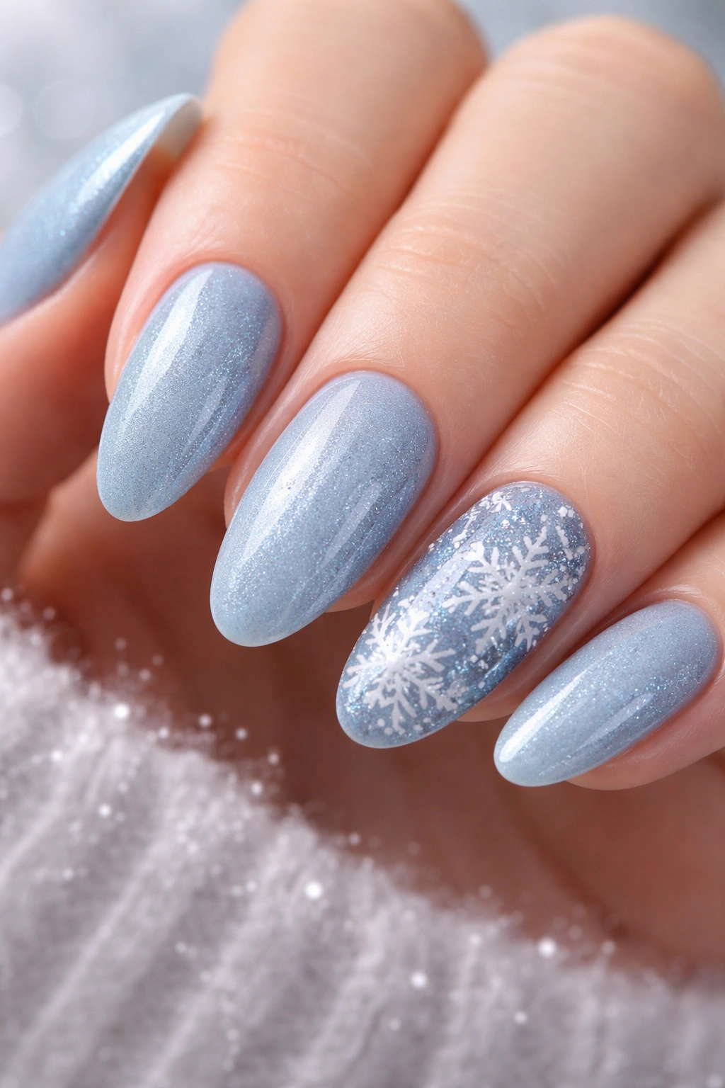 Close-up of snowflake accent nails on icy blue base