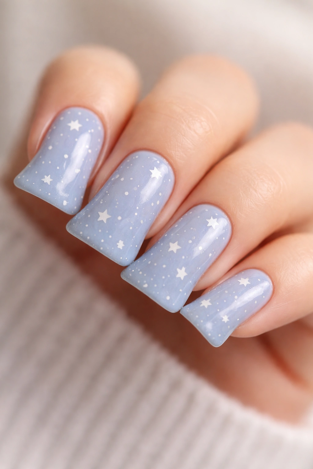 Close-up of duck nails in soft blue with white stars