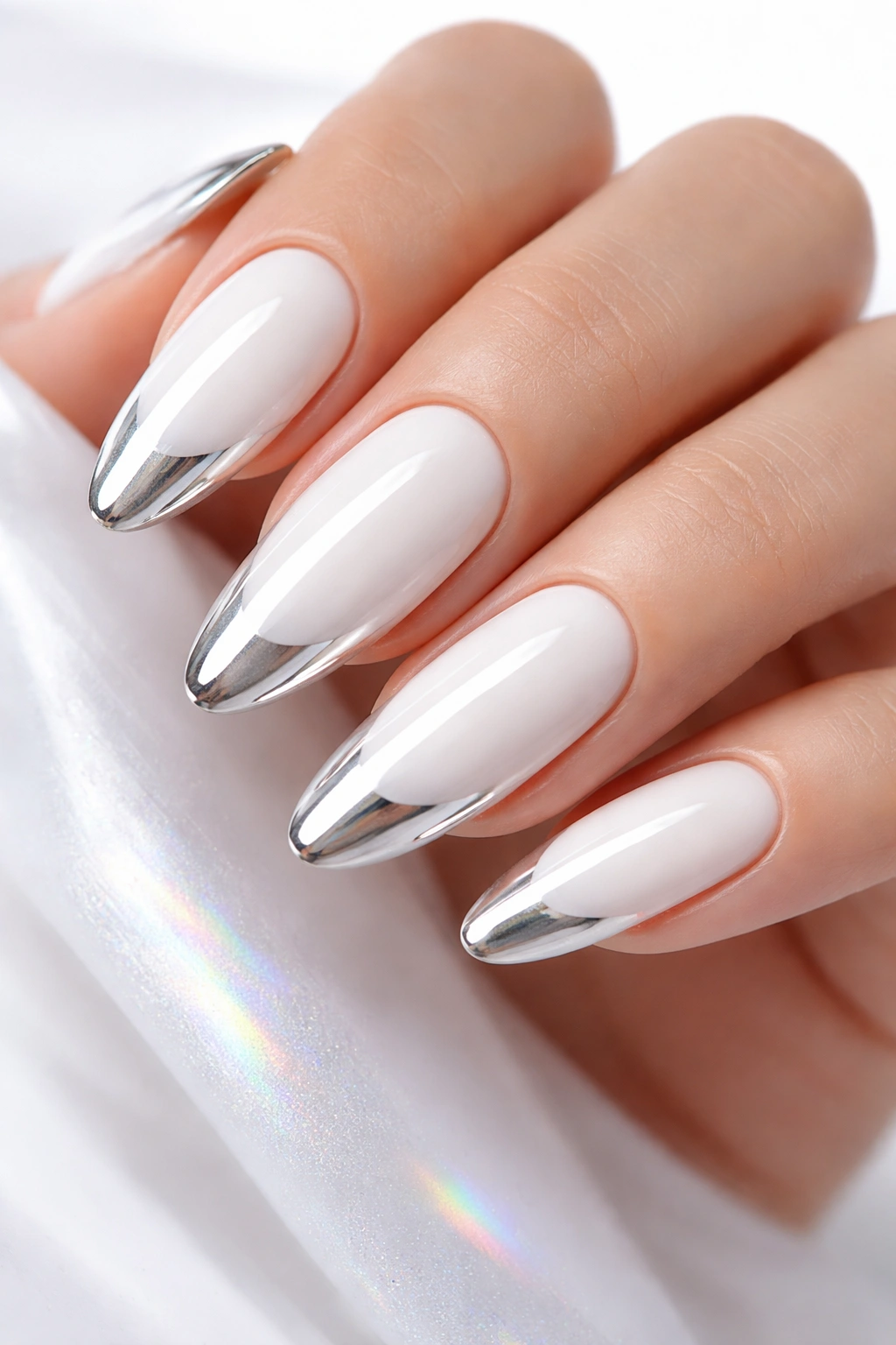 Close-up of long oval nails with white base and chrome tips
