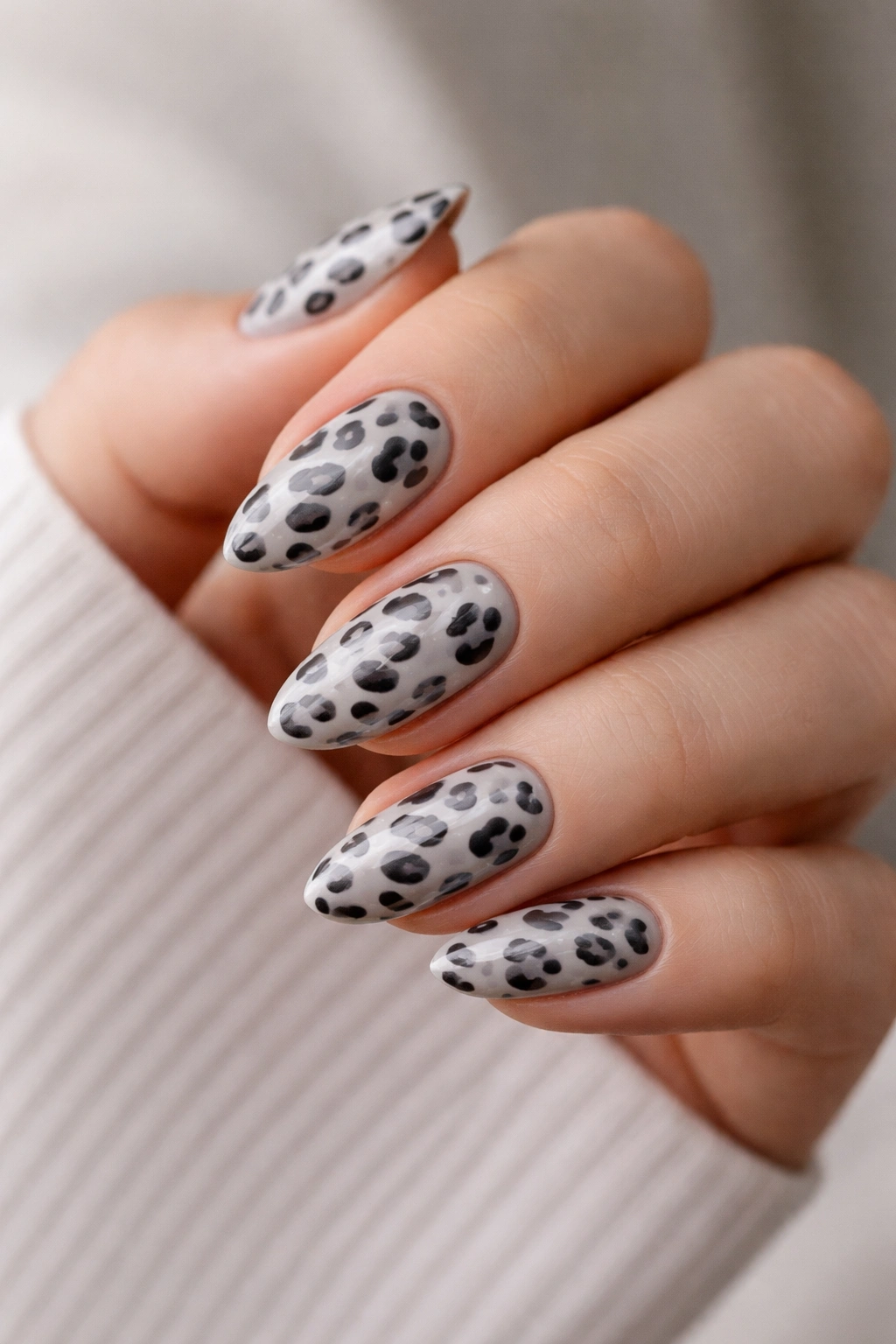Short almond nails in soft gray leopard design with partial outlines
