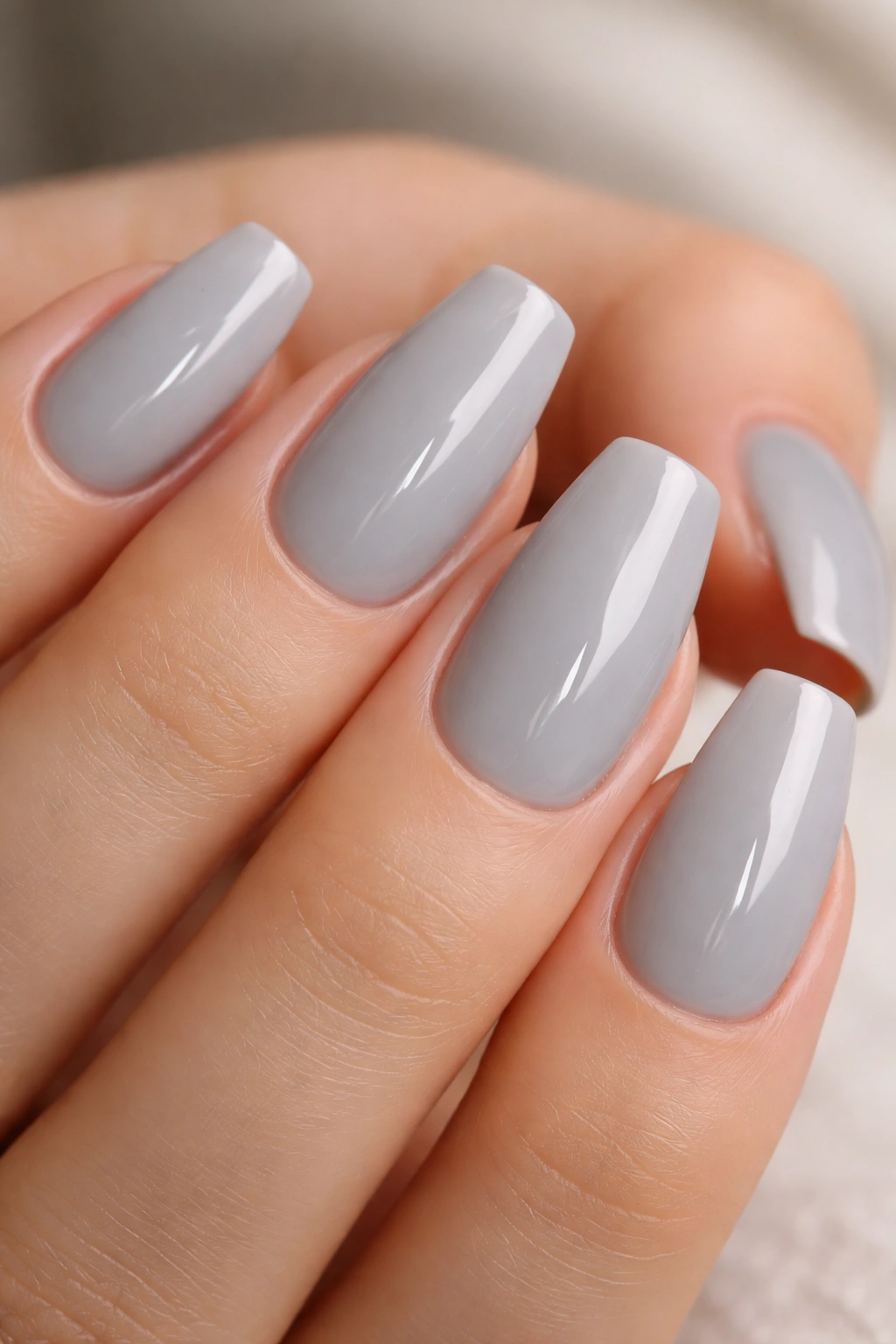 Soft gray nails with a high-gloss top coat on short ballerina nails