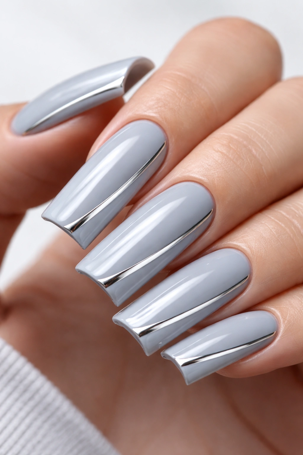 Close-up of a duck nail with soft grey base and chrome detail