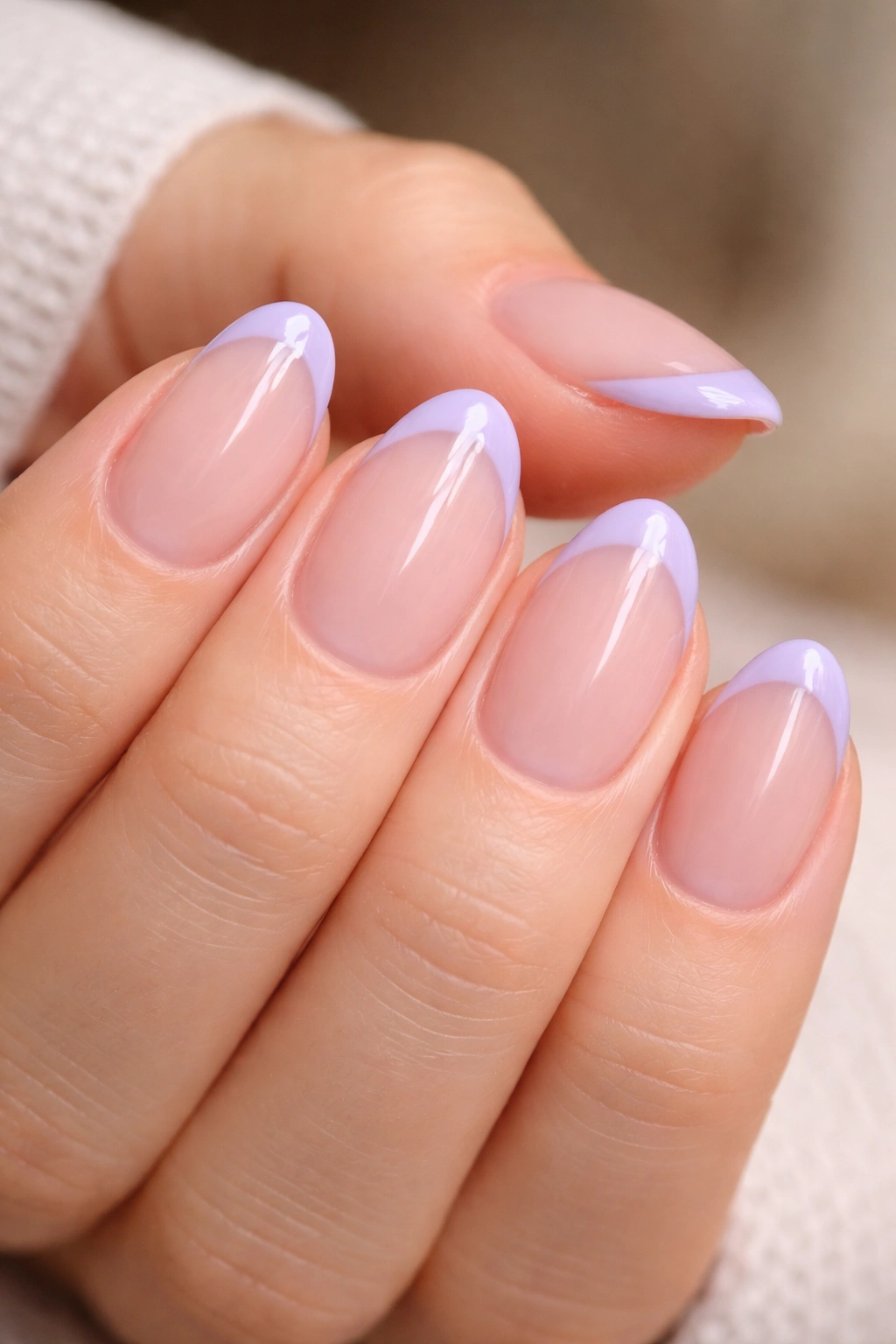 Close-up of short almond nails with soft lavender French tips