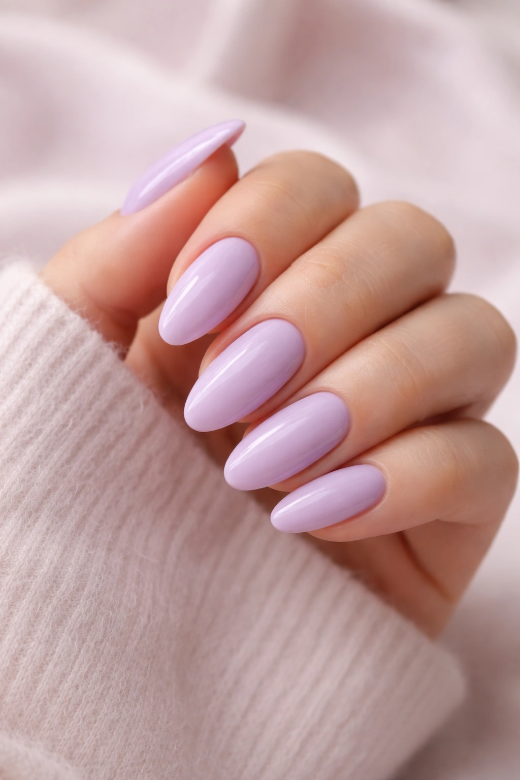 Close-up of soft lilac almond nails with glossy finish on a hand