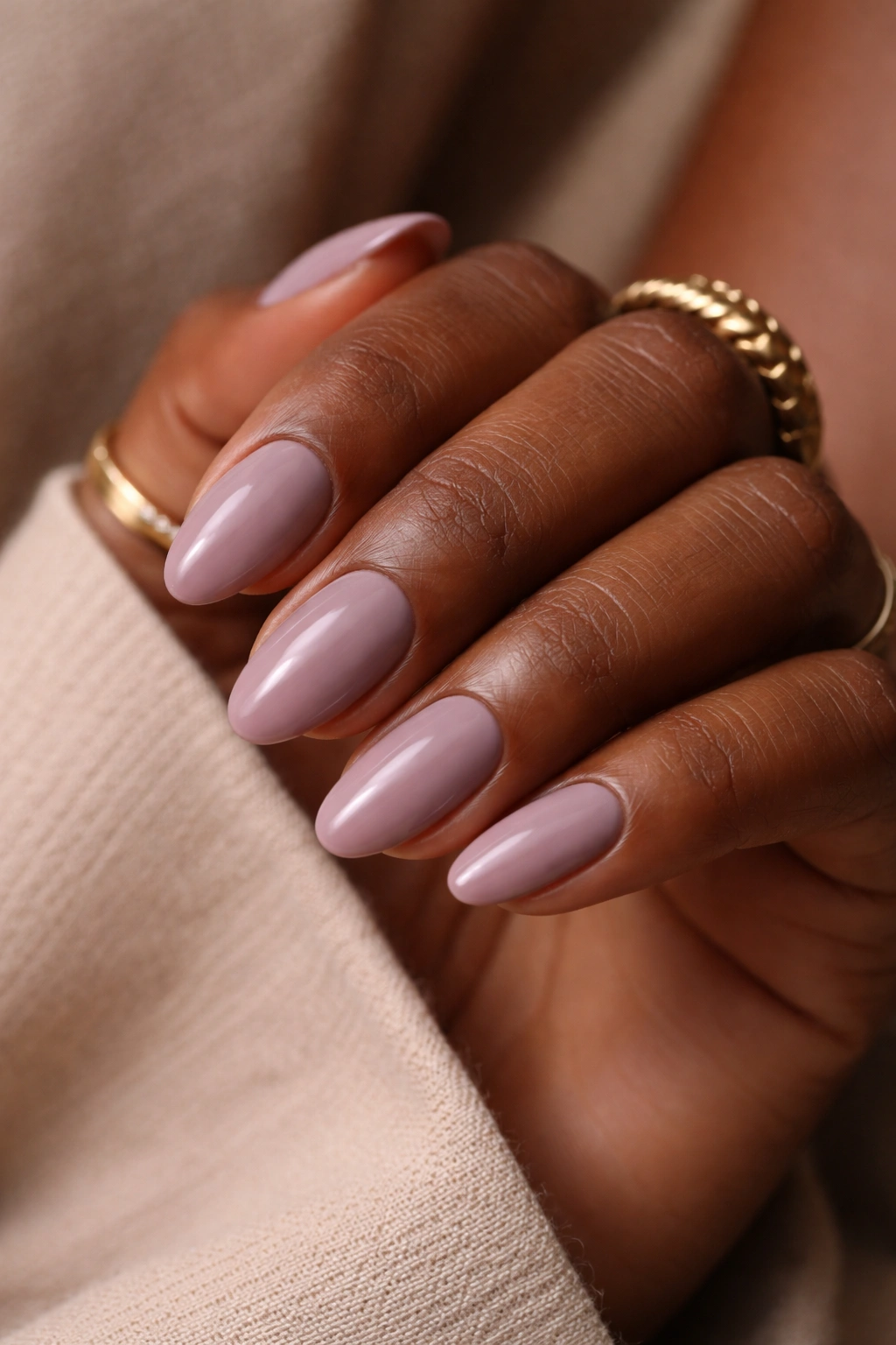 Close-up of a hand with soft mauve short almond nails