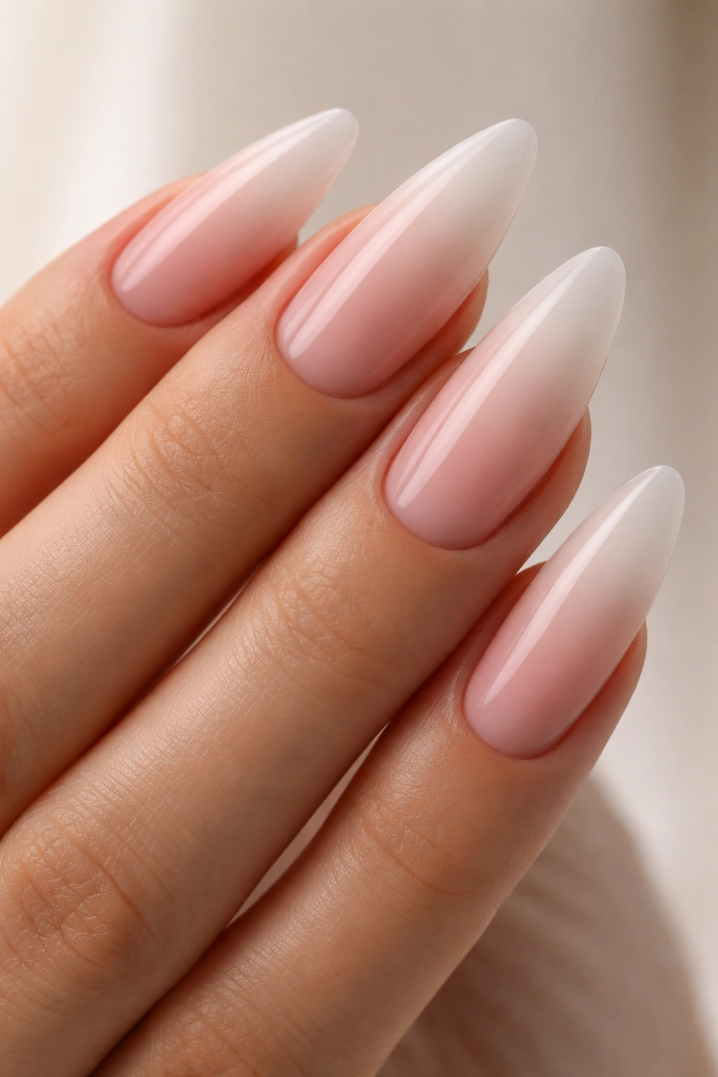 Long almond nails with soft pink to nude to white ombré gradient