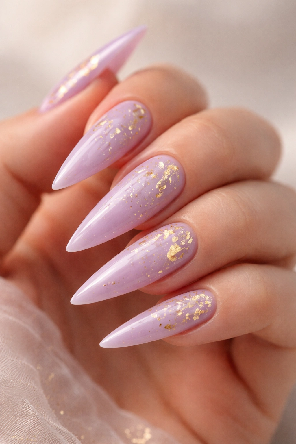 Soft purple stiletto nails with gold leaf flecks