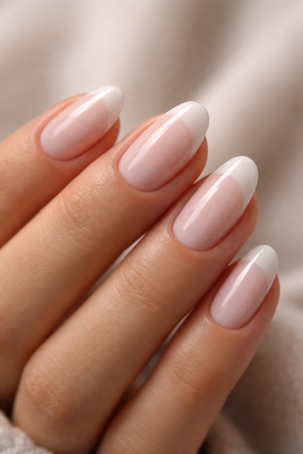 Close-up of short almond nails with sheer milky white glaze on tips
