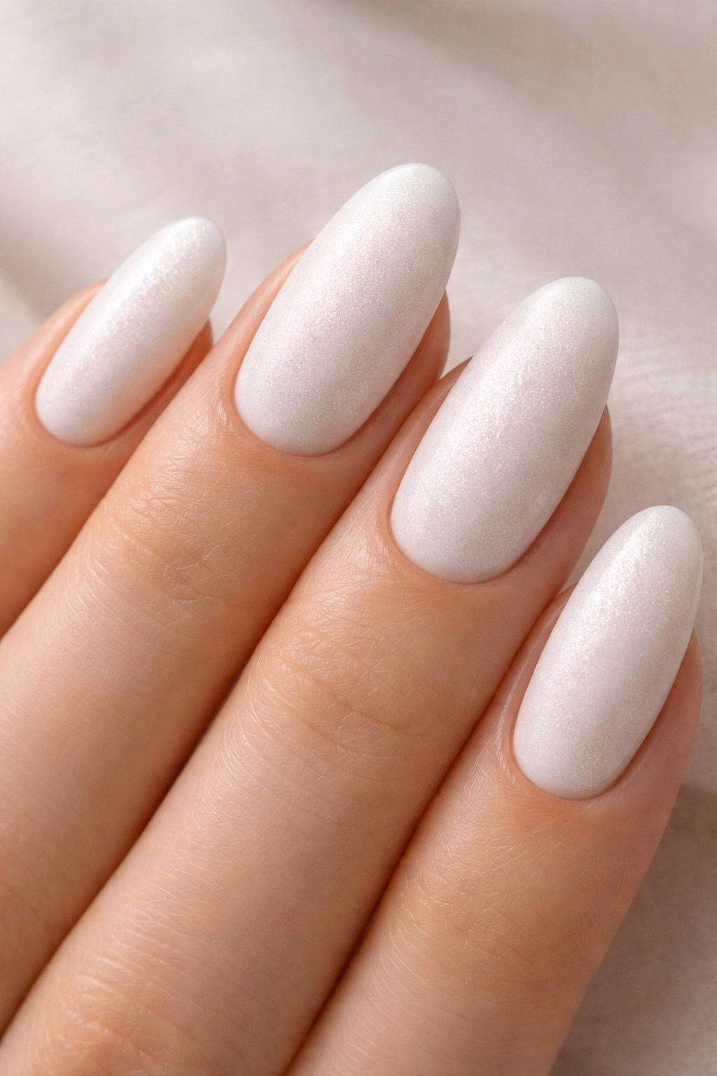 Oval nails with soft white base and barely visible grain texture.